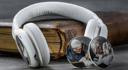 A pair of Onanoff white StoryPhones (headphones) rests on a vintage book, showcasing circular StoryShields customized with family photos.